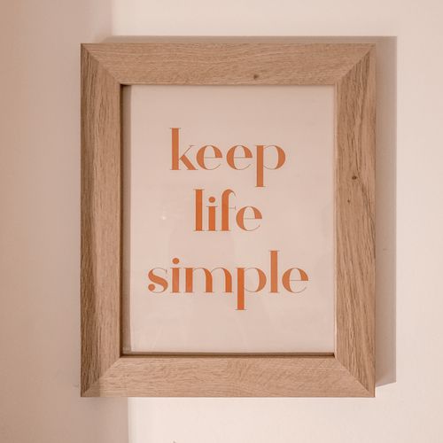 Free Minimalist framed art with motivational quote 'keep life simple' against a neutral background. Stock Photo