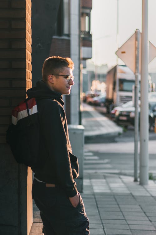 Man Standing Near Brown Brick Wall