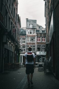男子漫步在比利时那慕尔迷人的街道上，历史悠久的建筑尽显风采