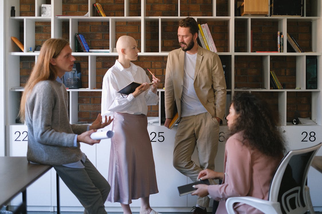 Serious coworkers sharing business ideas and discussing project in modern office during teamwork