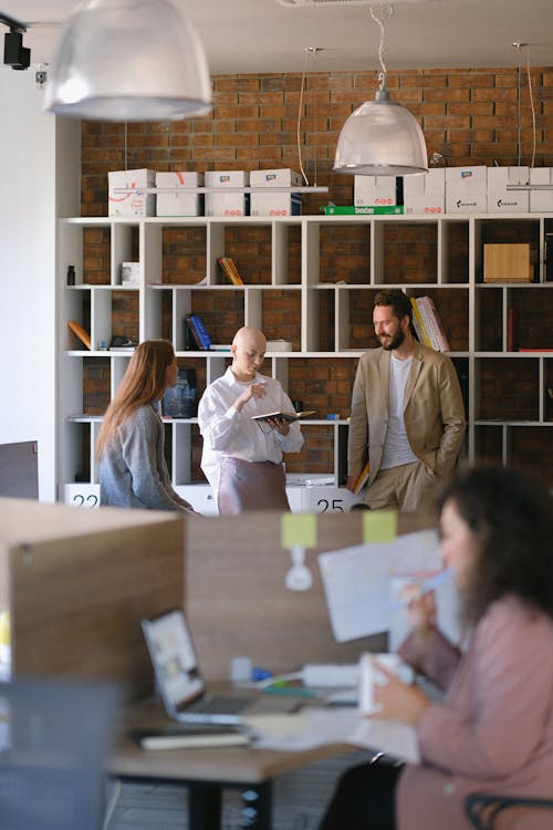 Free Team of coworkers gathering in open space office and sharing business and project issues together Stock Photo