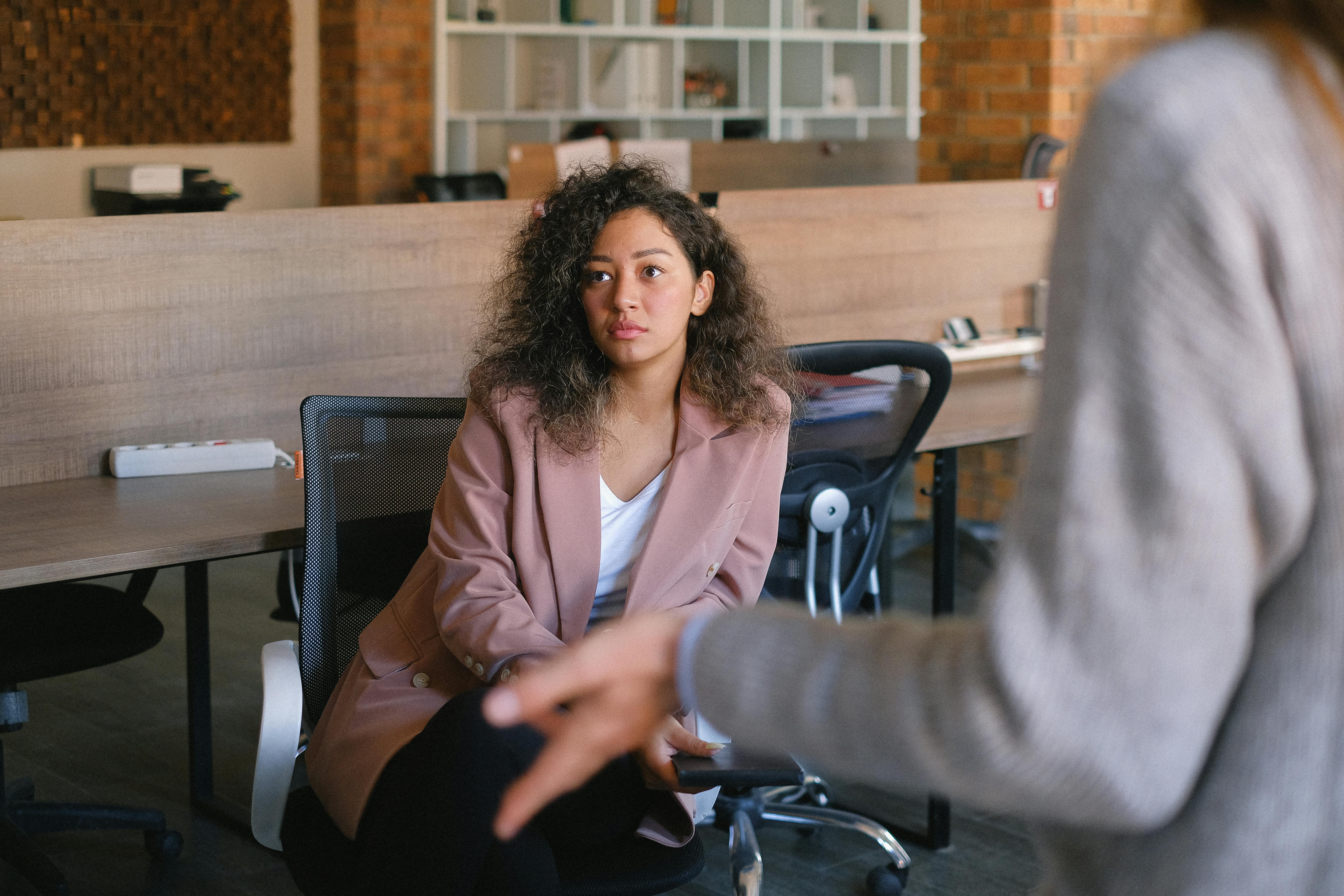 serious woman listening to colleague in office