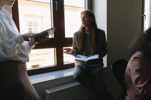 Team members discussing a project in a modern office setting by the window.