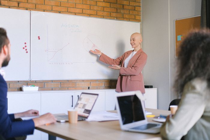 Presenter walking a team through a chart at a whiteboard — photo by Anna Shvets on Pexels