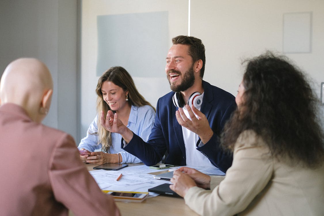 Free Happy group of colleagues talking and sharing opinions at table in conference in business office Stock Photo