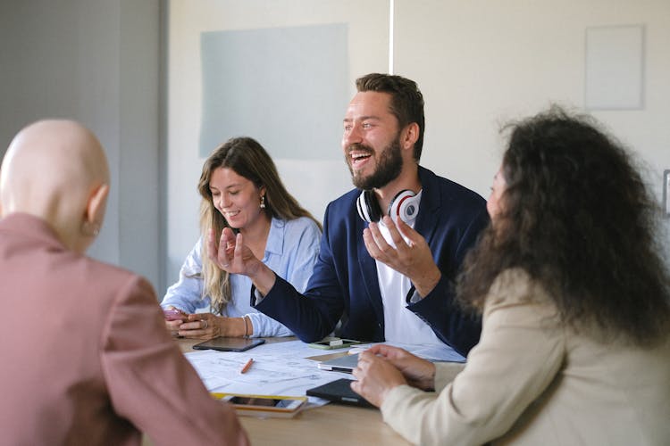 Group Of Cheerful Businesspeople Discussing Strategy