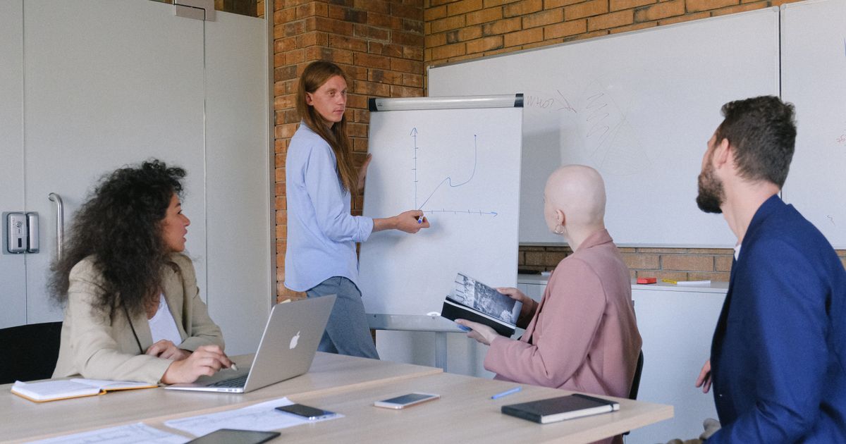 A UK entrepreneur presenting a business plan with graphs and charts to a group of potential investors.