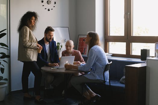 Multiethnic young ambitious businesspeople in formal outfits discussing job at table of office in daytime