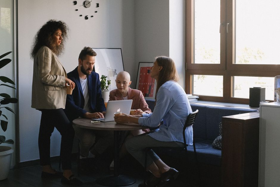Term Life vs Whole Life for Young Families: Coverage & Cost Showdown Multiethnic young ambitious businesspeople in formal outfits discussing job at table of office in daytime