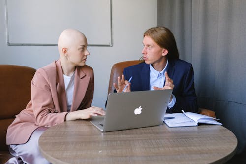 Focused young man explaining business strategy to female colleague