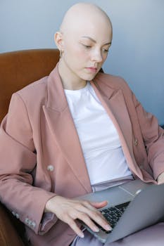 Businesswoman concentrating on laptop work in a modern indoor setting.