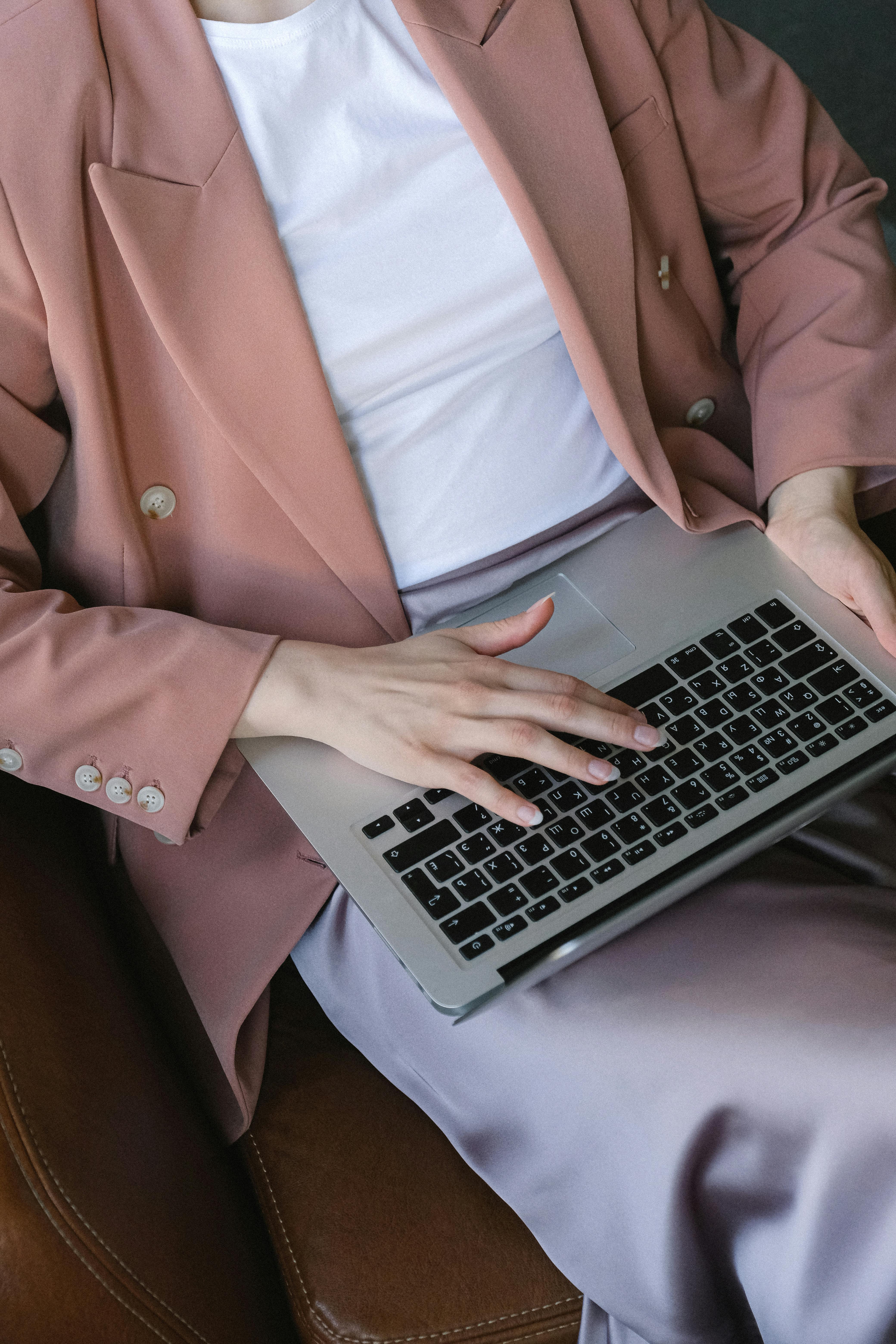 businesswoman sitting with portable laptop on knees while typing