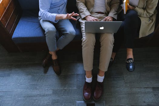 Three professionals collaborating using a laptop, emphasizing teamwork and technology.