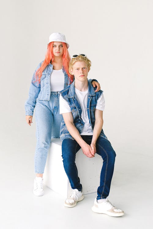 Free Full body of unemotional teens wearing trendy denim outfits and sneakers in studio Stock Photo