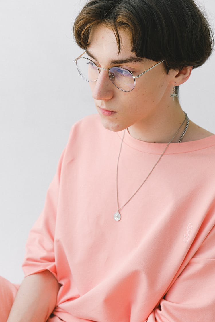 Thoughtful Teen Man In Eyeglasses And Orange Long Sleeve Shirt