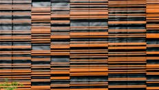 现代建筑立面的特写展现了由橙色和黑色面板构成的引人注目图案