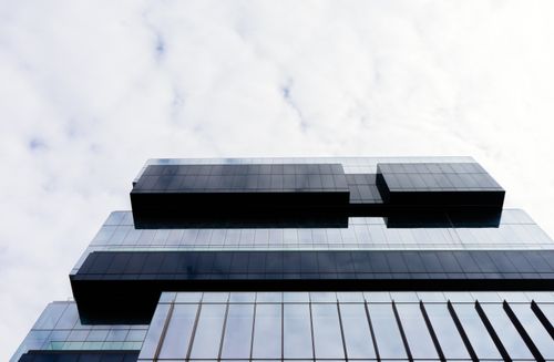 Free Contemporary building with a glass facade and geometric patterns, low angle view. Stock Photo