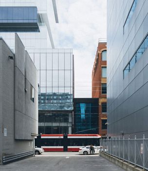 在城市的小巷中，现代有轨电车穿行于高层建筑之间