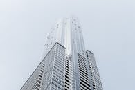 从低角度拍摄，一座具有几何玻璃立面的现代摩天大楼引人注目