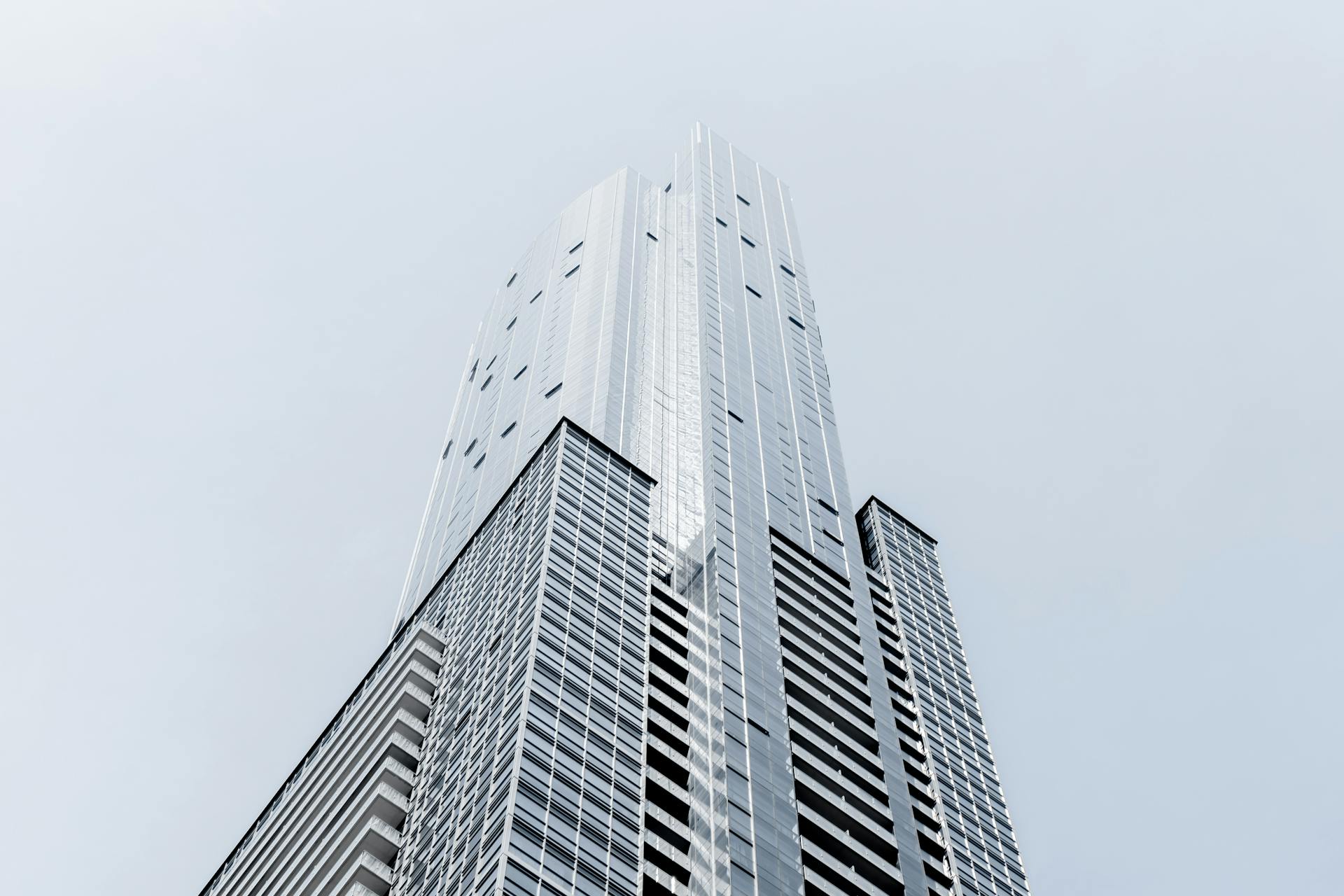 A striking modern skyscraper with a geometric glass facade, captured from a low angle.