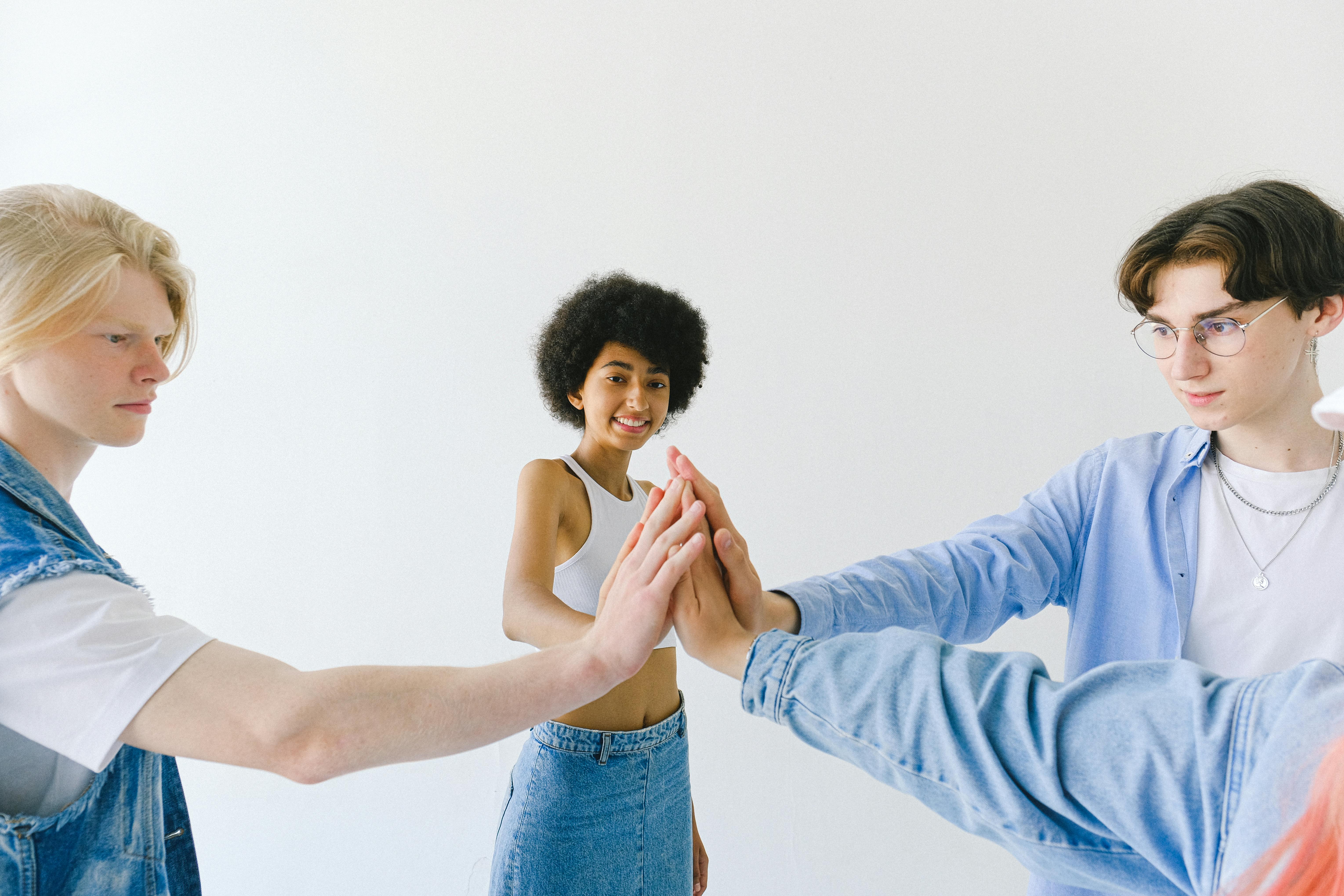 smiling diverse teenagers with hands stacked