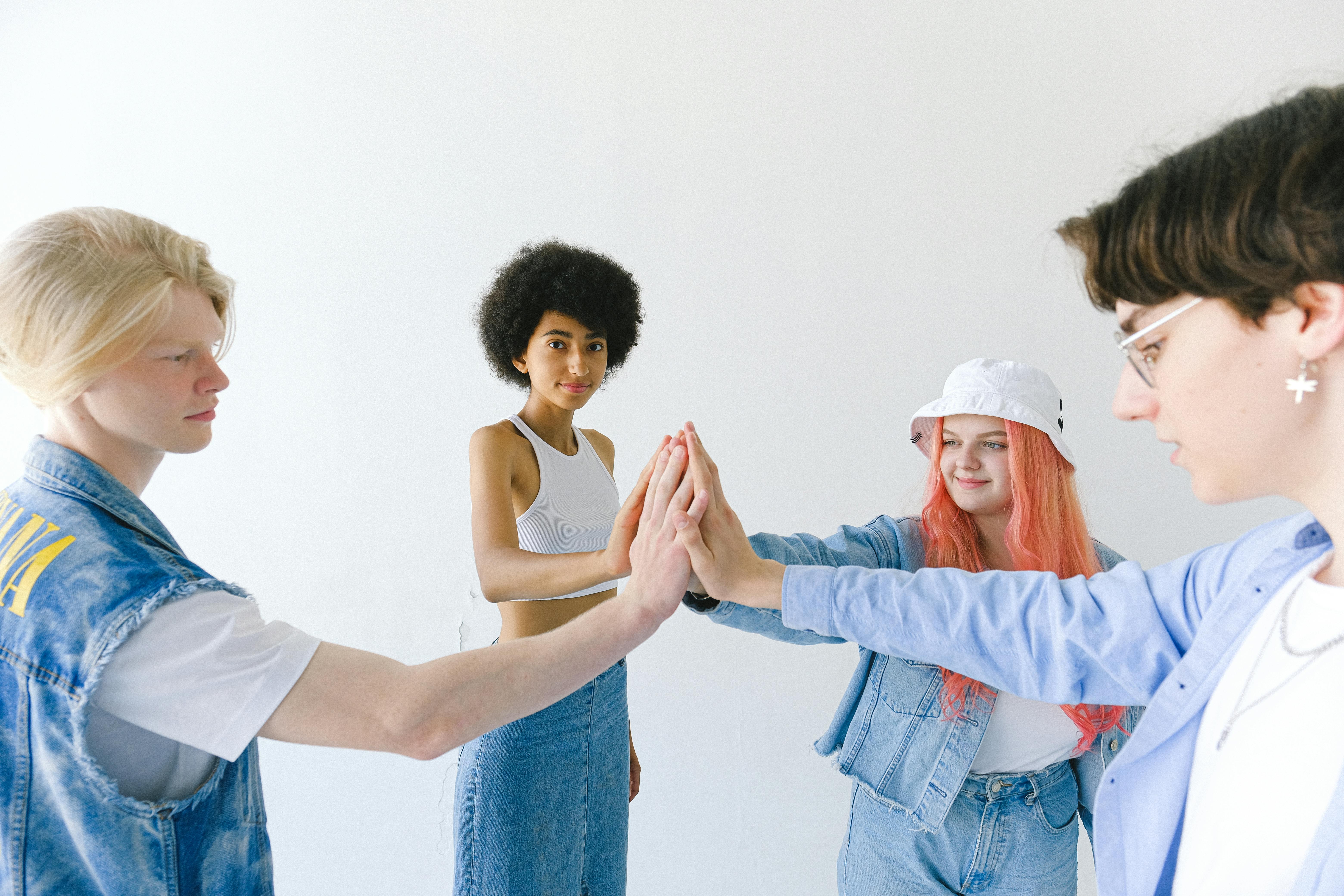 smiling multiethnic group of teenager friends with hands stacked