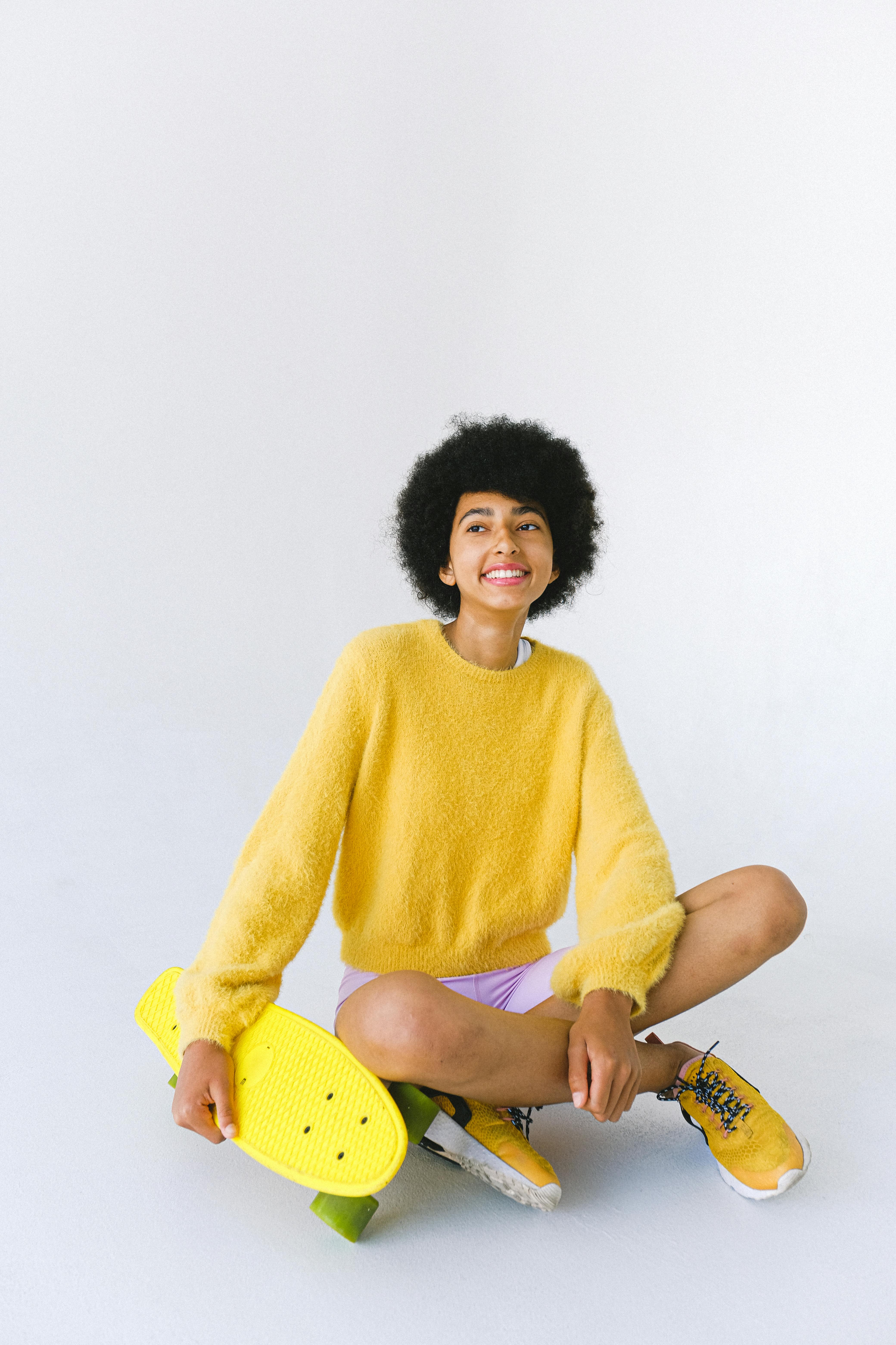 black teenager with penny board looking away