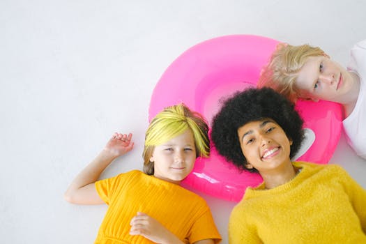 从上方看，多种族青少年快乐地微笑着，注视着白色背景上漂浮物上的镜头