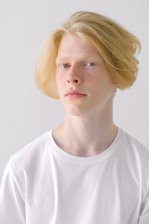 Free Teenager in white t shirt with stylish haircut looking at camera on white background of studio Stock Photo