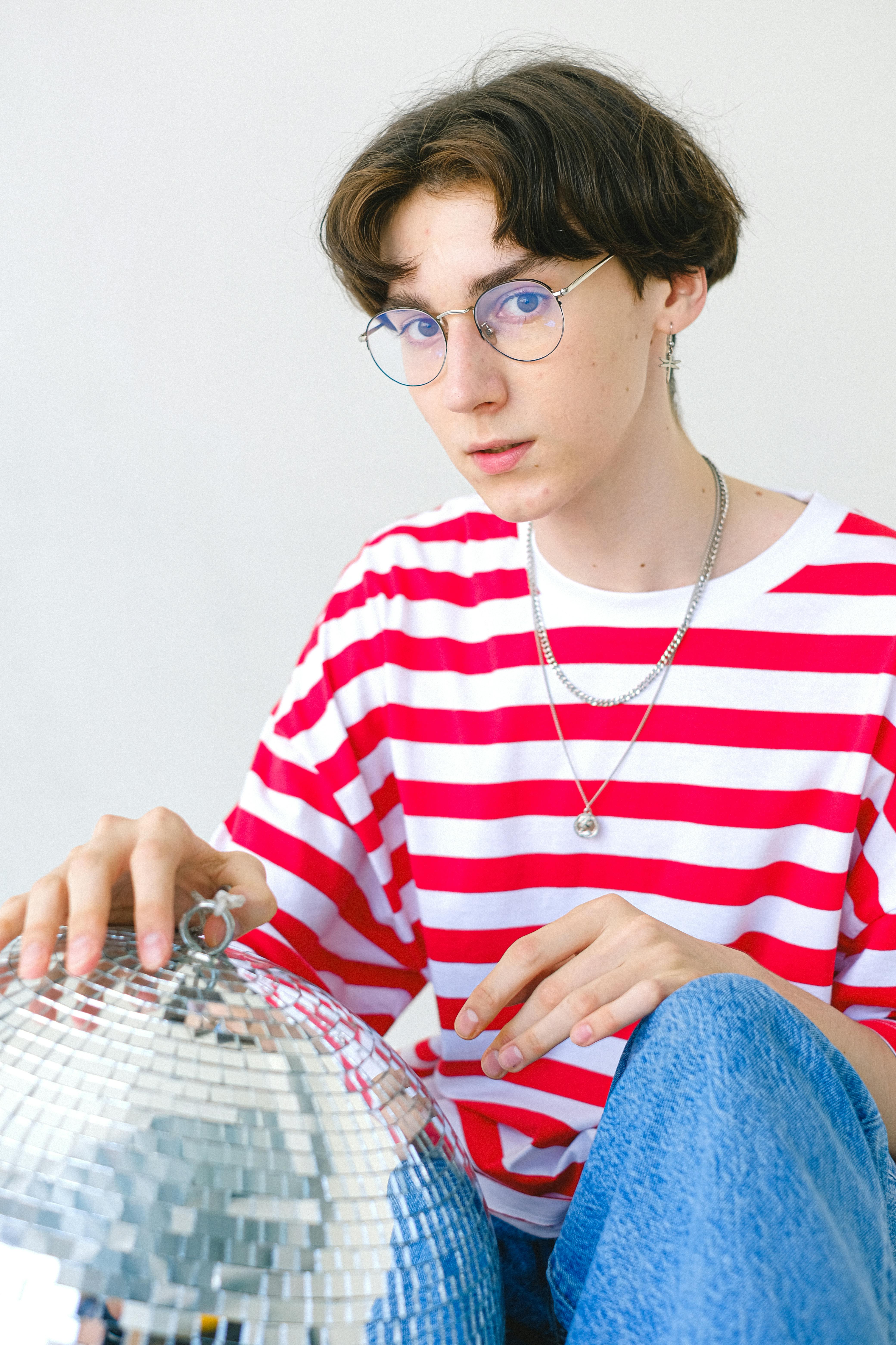 teenage boy in striped t shirt with disco ball