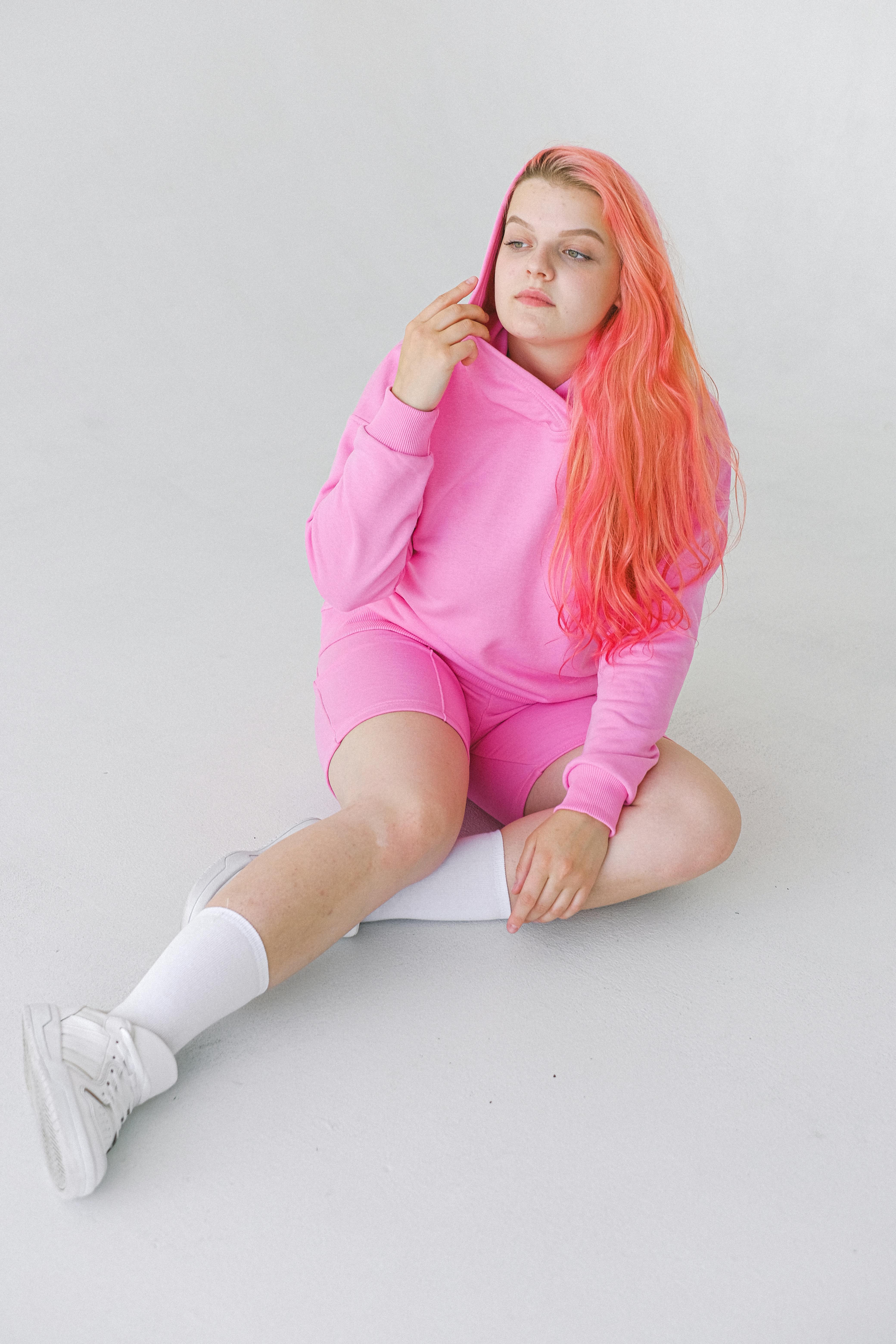 teenage girl with pink hair in hoodie