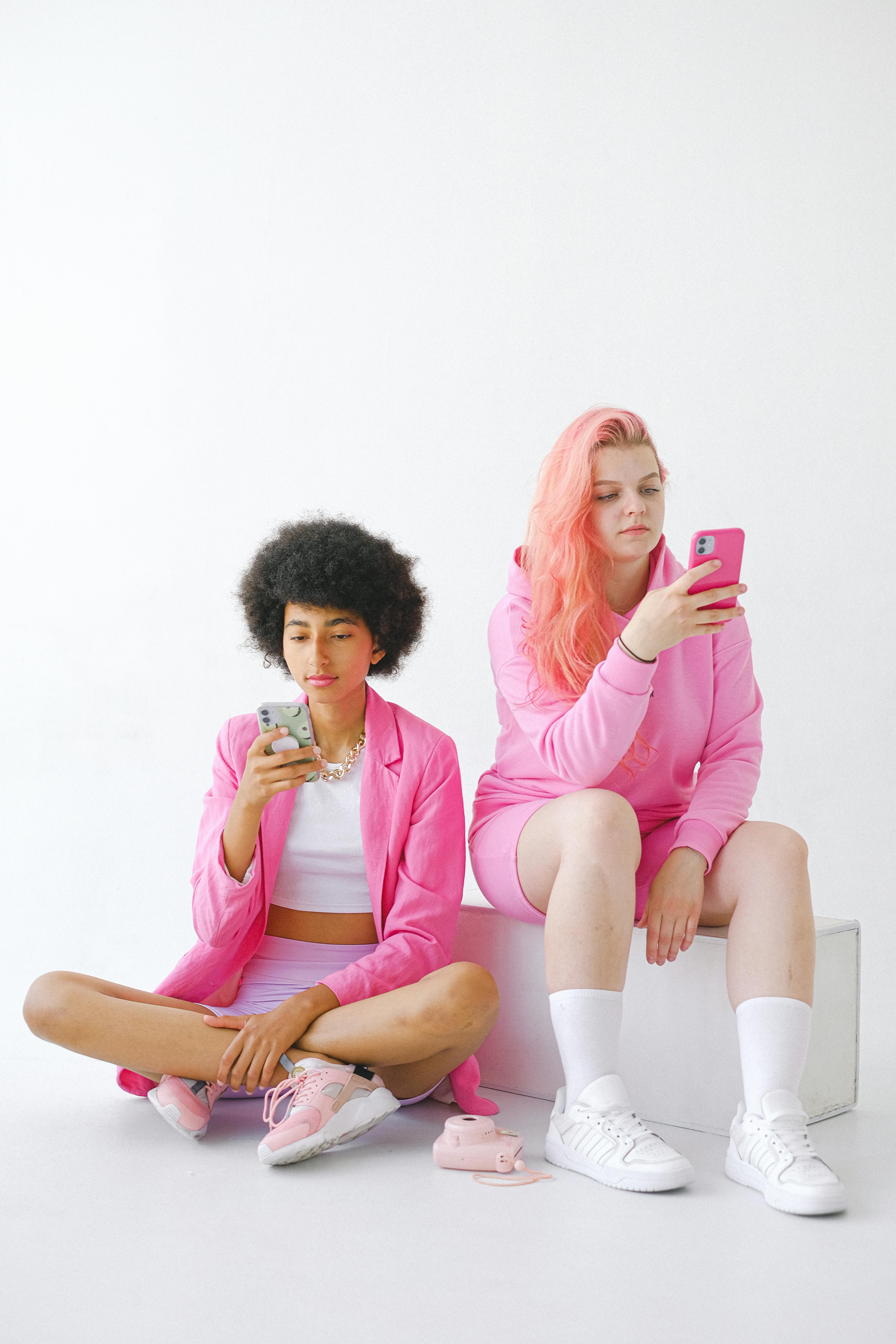trendy multiracial teenagers using smartphones in studio