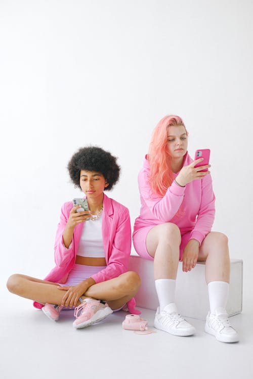 Trendy multiracial teenagers using smartphones in studio