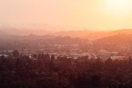 Wonderful pink sky over town surrounded by mountains and forest