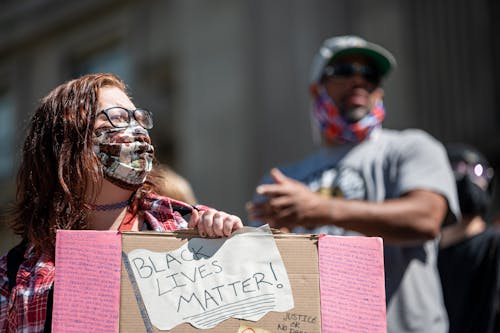 Unrecognizable woman with poster on street