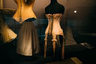 Through glass view of various old style female corsets and petticoats in museum