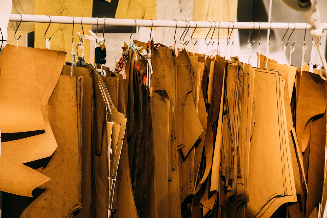 Collection of paper dress patterns hanging in workshop · Free Stock Photo