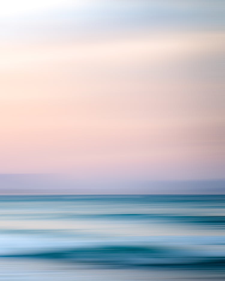 Magnificent View Of Ocean Beneath Light Pink Sky