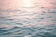 宁静的海浪反射着日落的柔和光芒，营造出宁静平静的氛围