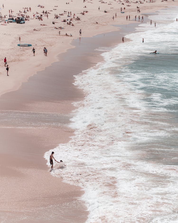 Crowded Beach Washed By Foamy Sea Waves