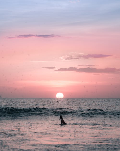 Pessoa Surfando No Mar Durante O Pôr Do Sol
