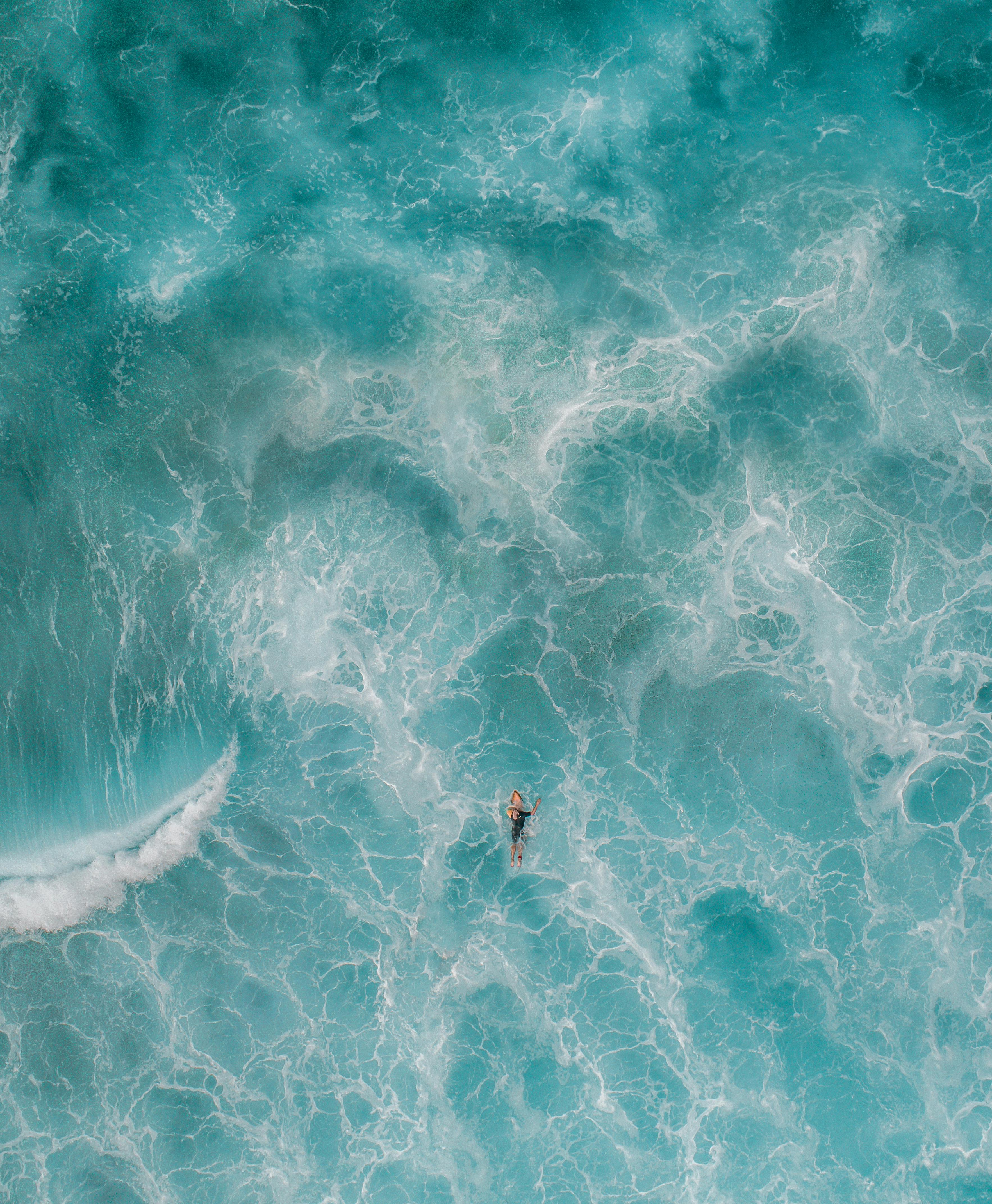 夏の旅行中にターコイズブルーの海で泳ぐ匿名の旅行者 無料の写真素材