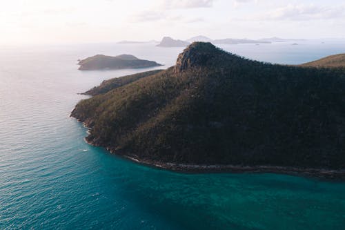 Mont De Verdure Près De La Mer Ondulée Sous Un Ciel Nuageux