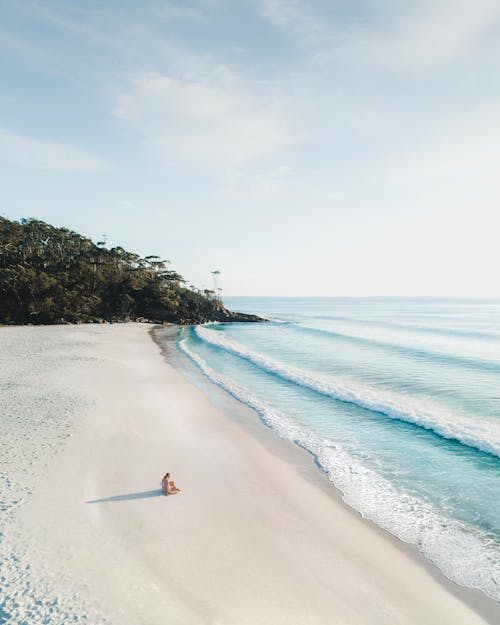 Anonymous traveler resting on sandy ocean beach in summer