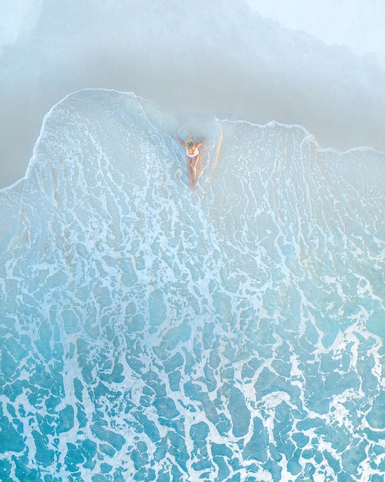 Anonymous Female Traveler Resting On Sandy Sea Shore