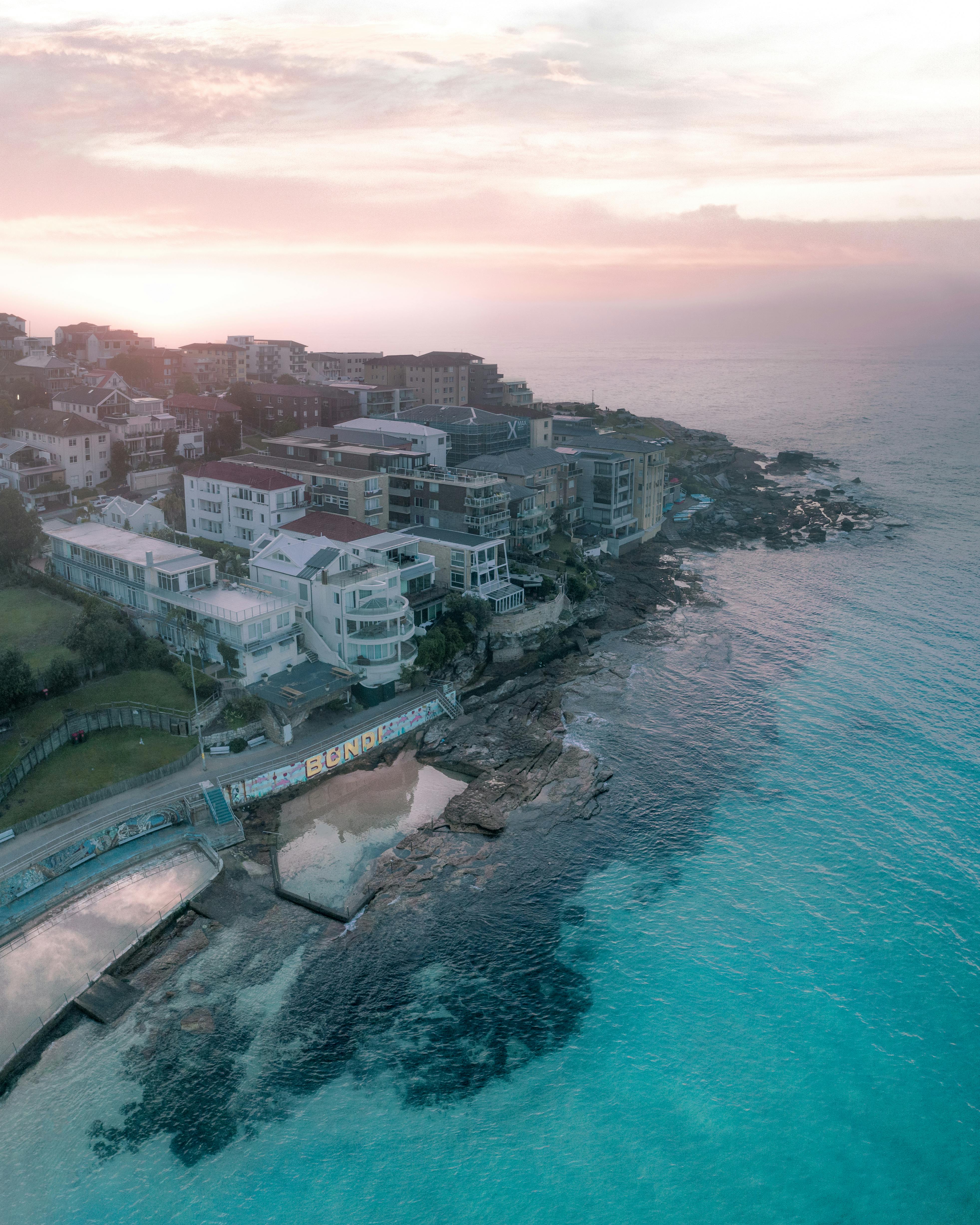 building facades near sea under cloudy sky at sundown