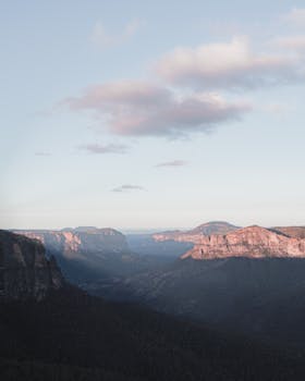 Peaceful mountainous landscape under a soft blue sky, perfect for nature lovers.
