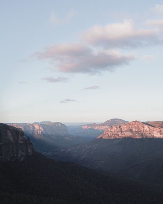 Spectacular scenery of tall rocky formations highlighted with sunlight under blue sky