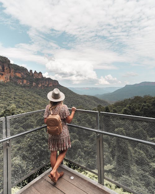 Traveling woman admiring mountains with green forest