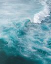 Drone view of turquoise water of ocean with large foamy waves in sunny day